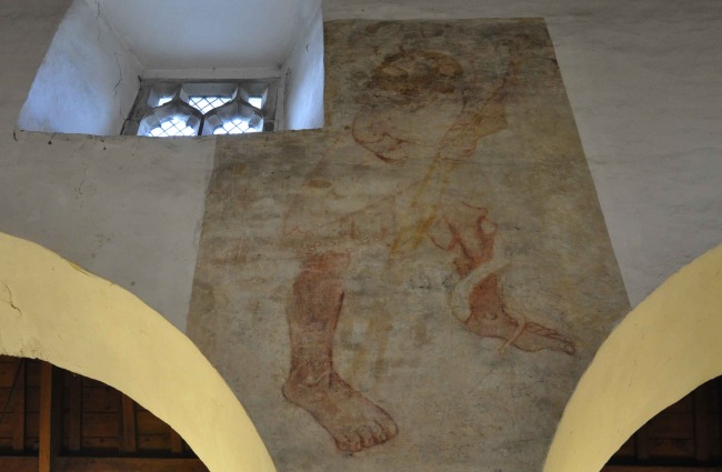 Medieval wall painting depicting Saint Christopher crossing a stream painted around 1400.